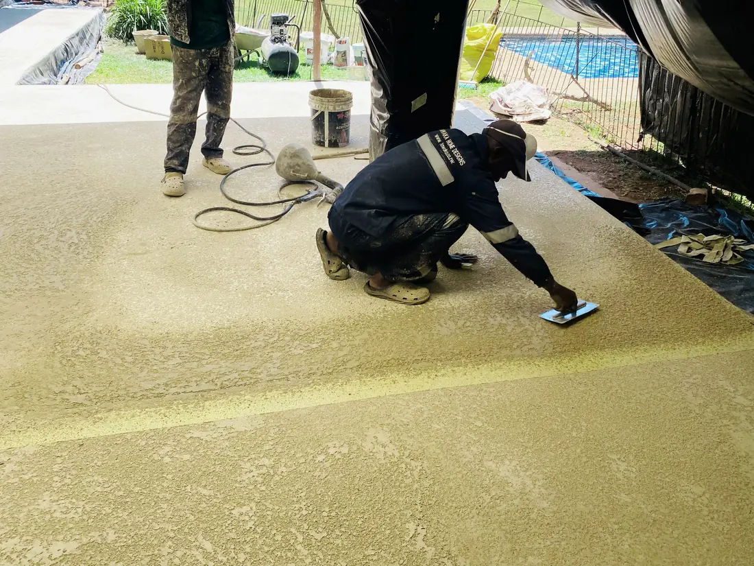 Tawaka Contracting applying a cementitious pool surround coating by hand in Highlands, Zimbabwe