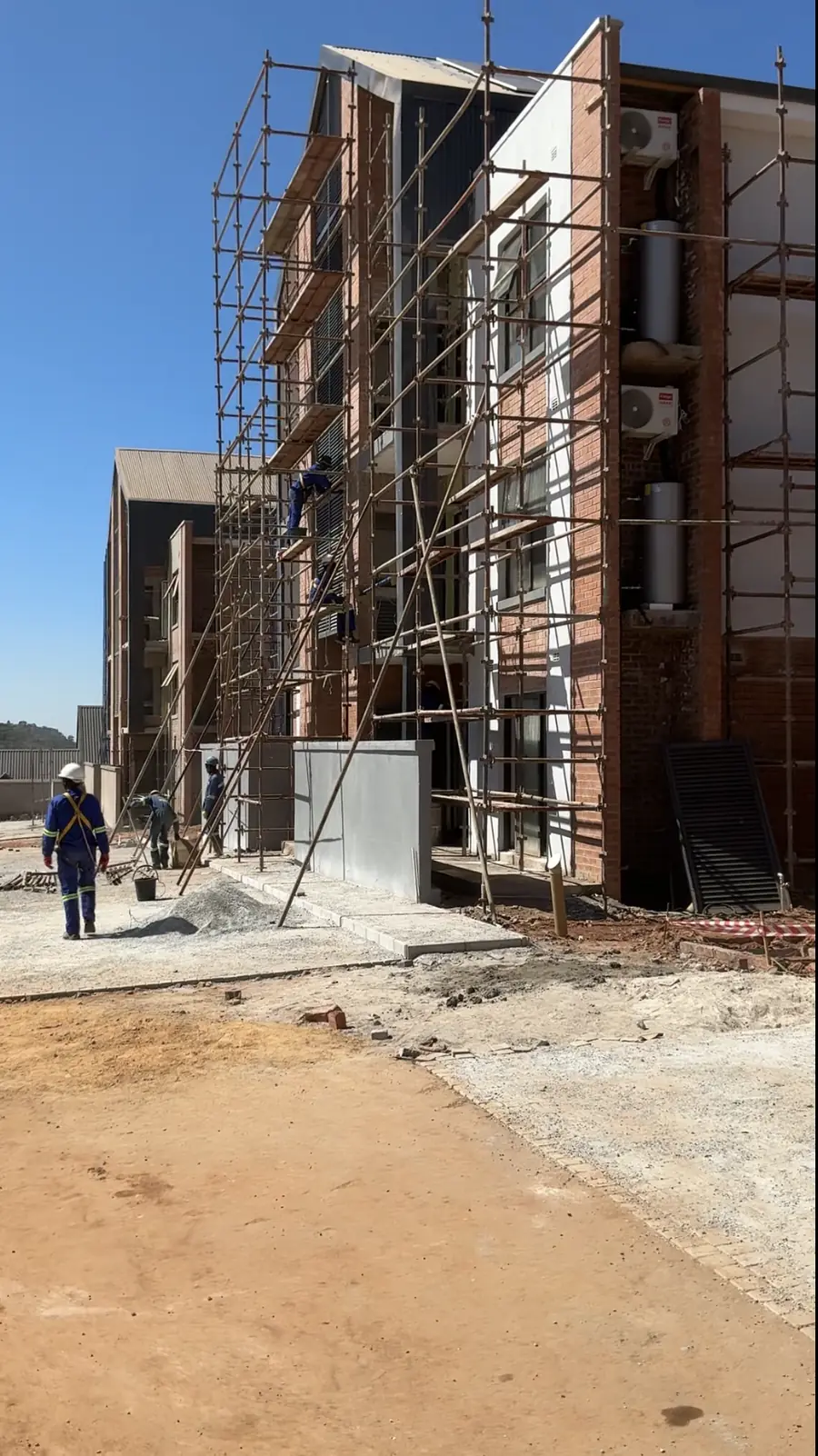 Commercial construction Harare — multi-storey apartment block under construction with scaffold access, Zimbabwe