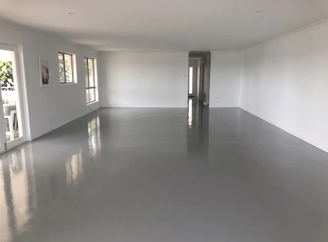 Interior epoxy flooring Harare — seamless grey resin floor through an open-plan residential living space