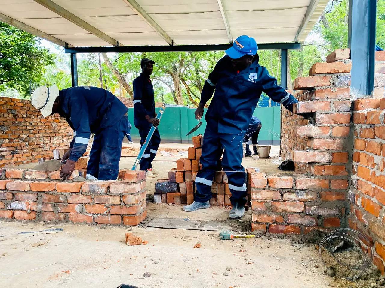Construction services Zimbabwe — Tawaka Contracting bricklaying team building walls under a steel canopy in Highlands, Harare