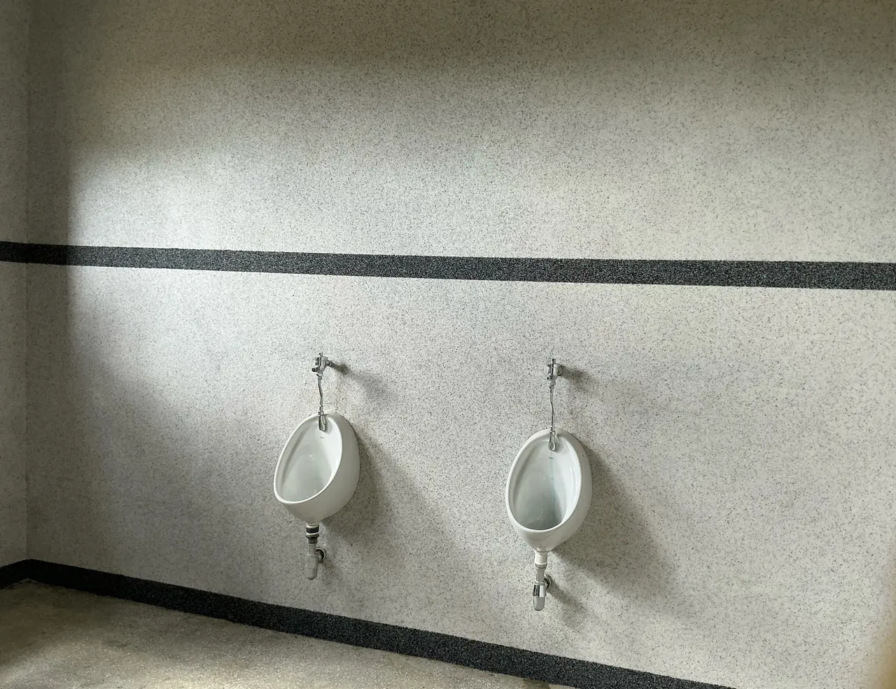 Terrazzo-effect wall and floor finishes Zimbabwe — speckled aggregate surfaces in a commercial washroom