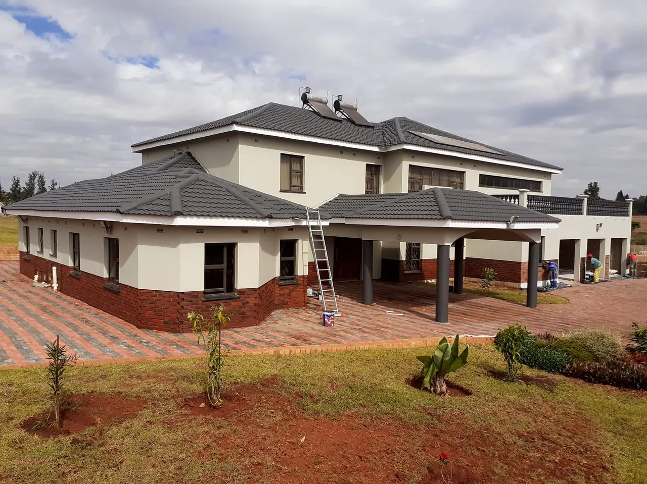 Construction company Harare — completed double-storey home in Gletwin with tiled roof, face-brick plinth and rendered finishes built by Tawaka Contracting