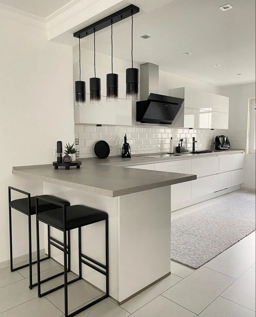 Completed kitchen renovation by Tawaka Contracting in Harare, with white gloss units, a concrete-effect peninsula worktop