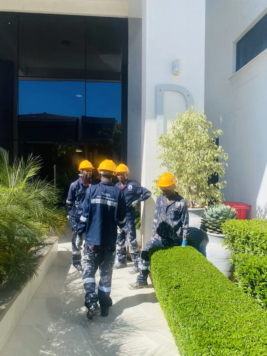 Construction team Harare — Tawaka Contracting site crew in hard hats at a commercial office entrance in Zimbabwe
