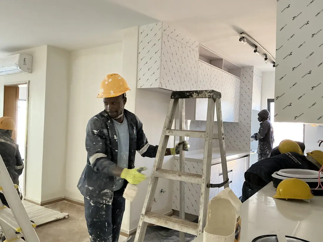 Interior painting and kitchen fit-out Harare — Tawaka Contracting painter finishing cabinetry during a residential renovation