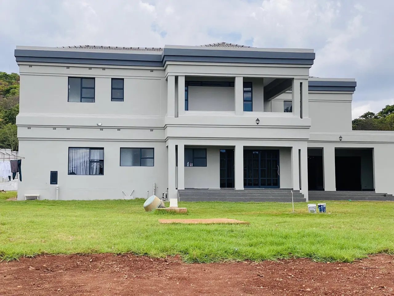Construction company Harare — completed double-storey house exterior in Gletwin with grey render and dark parapet detail