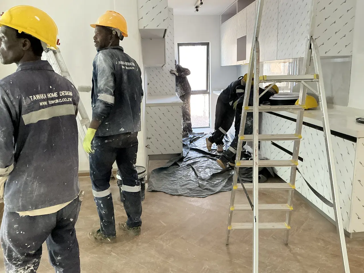Tawaka Contracting painting team in branded workwear fitting out a kitchen renovation in Harare, Zimbabwe