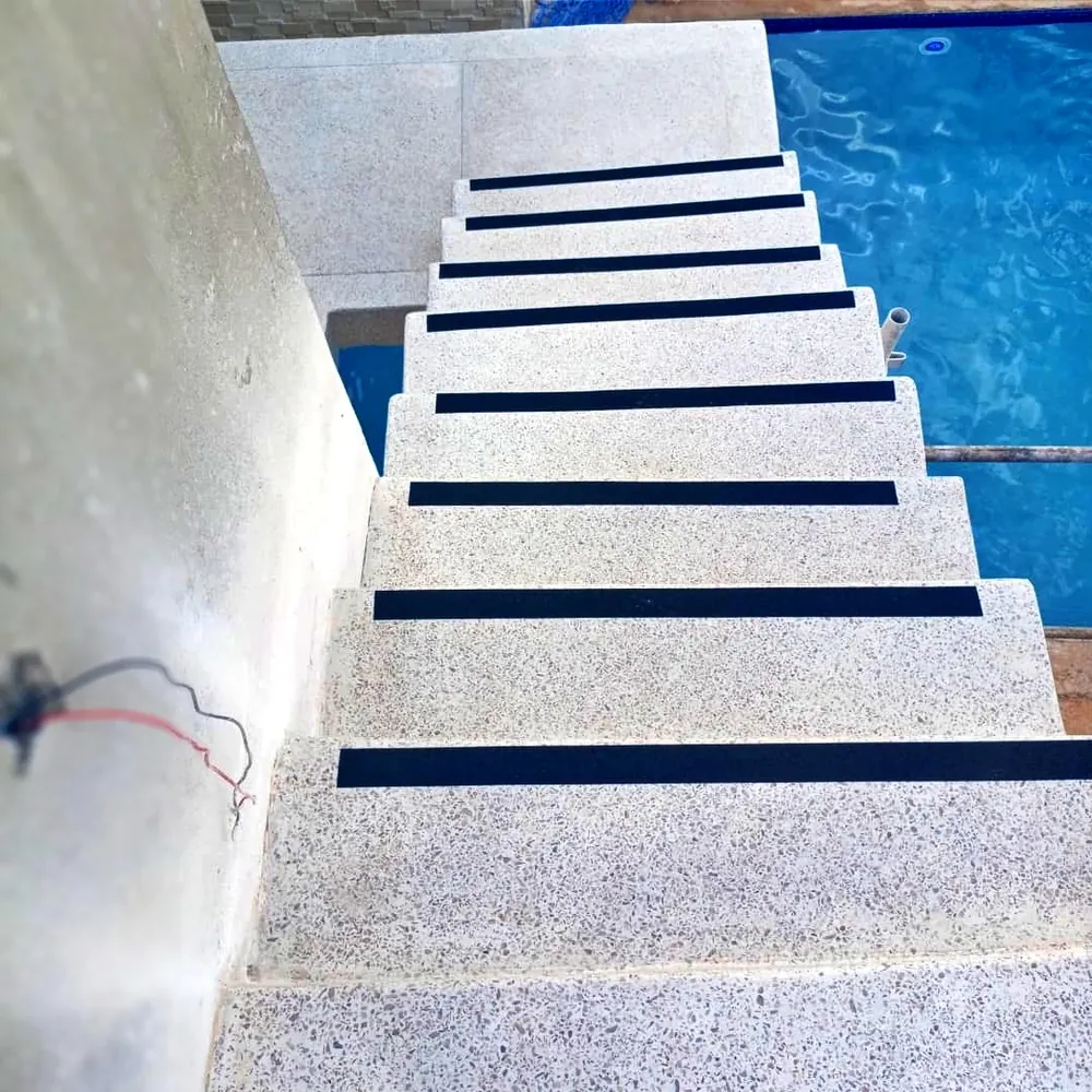 Terrazzo flooring Harare — poolside terrazzo staircase with black anti-slip inlay strips on every tread, Borrowdale Zimbabwe