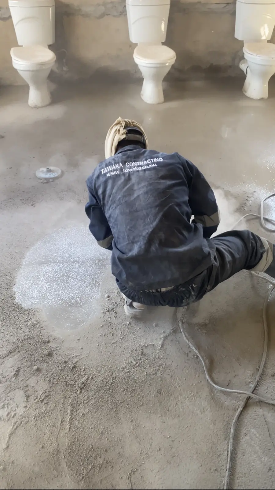 Tawaka Contracting operative machine-sanding a terrazzo washroom floor in Borrowdale, Harare, grinding the surface back
