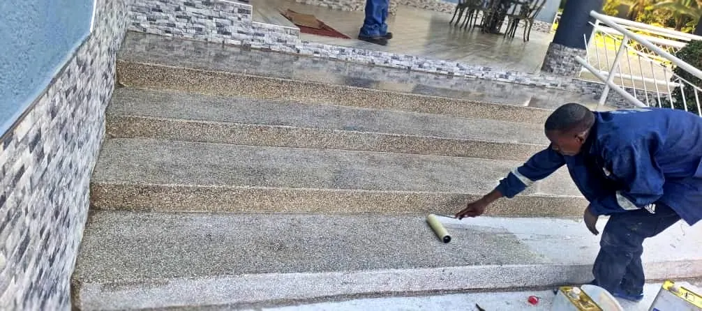 Tawaka Contracting operative roller-applying sealer to finished terrazzo steps in Borrowdale, Zimbabwe
